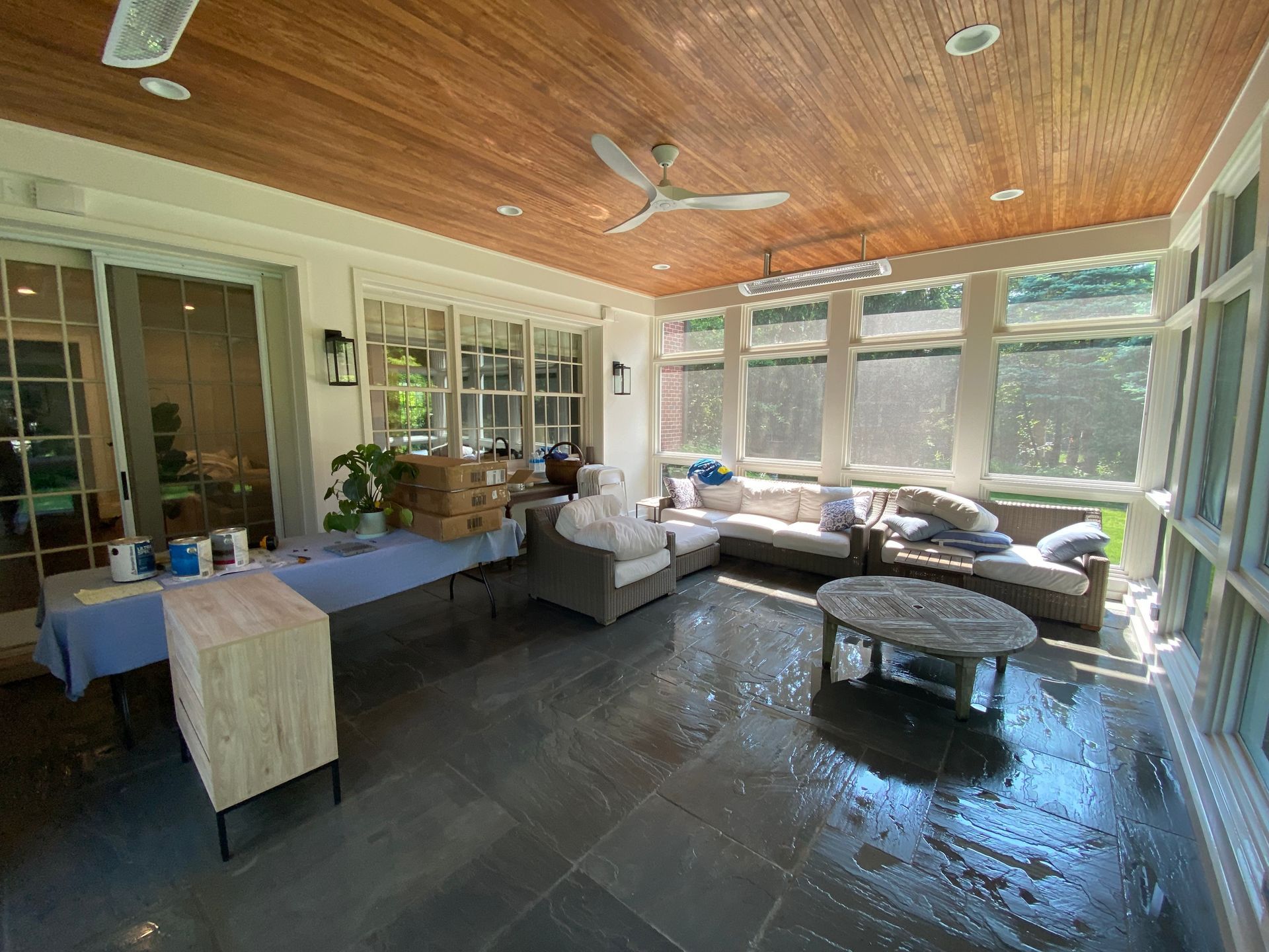 A living room with a lot of furniture and a ceiling fan.
