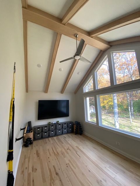 A living room with a lot of furniture and a ceiling fan.