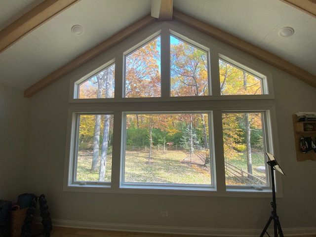 A room with a lot of windows and a ceiling fan