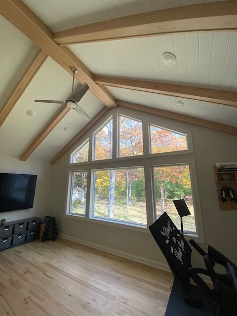 A living room with lots of windows and a ceiling fan