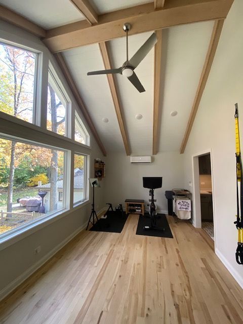 A room with a lot of windows and a ceiling fan