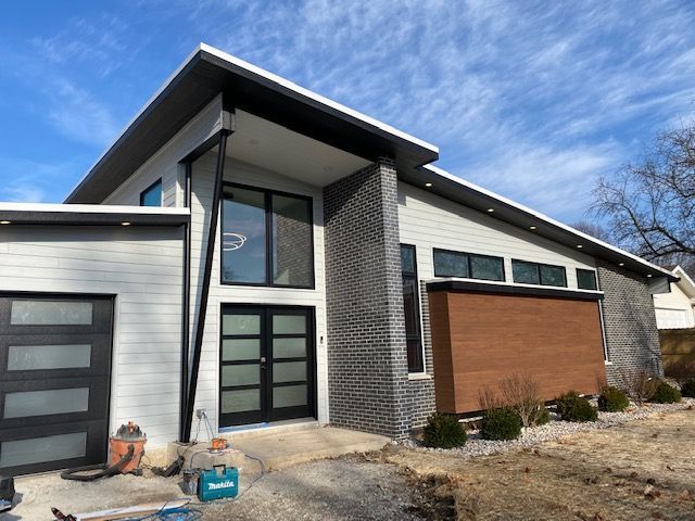 A modern house with a lot of windows and a garage door.
