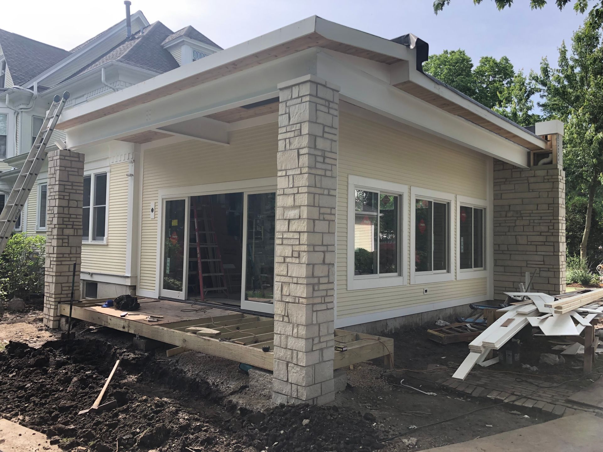 A house is being built with a lot of windows and brick pillars.