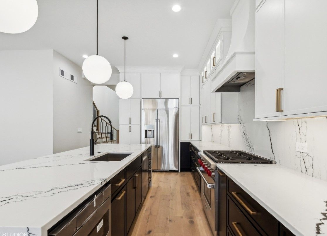 A kitchen with white cabinets and stainless steel appliances