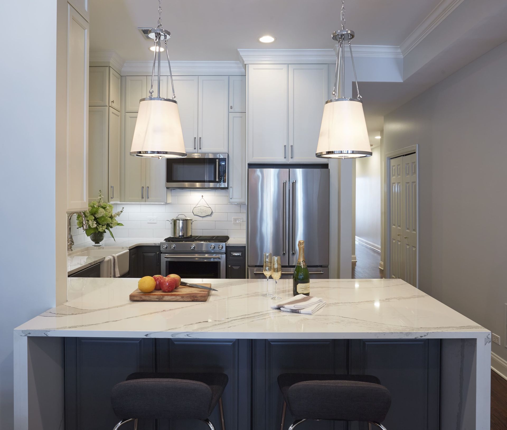 A kitchen with white cabinets and stainless steel appliances