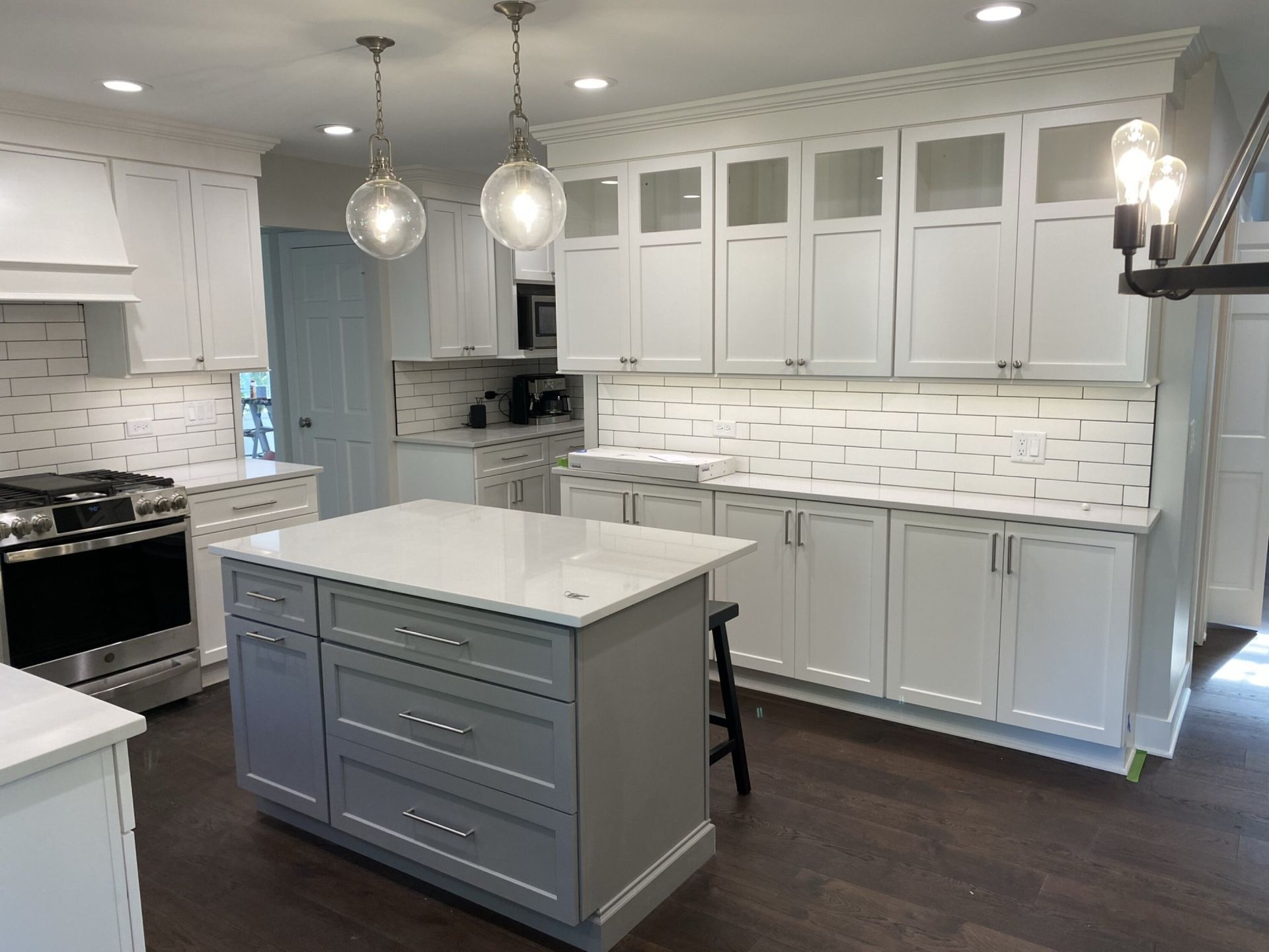A kitchen with white cabinets and a large island in the middle.