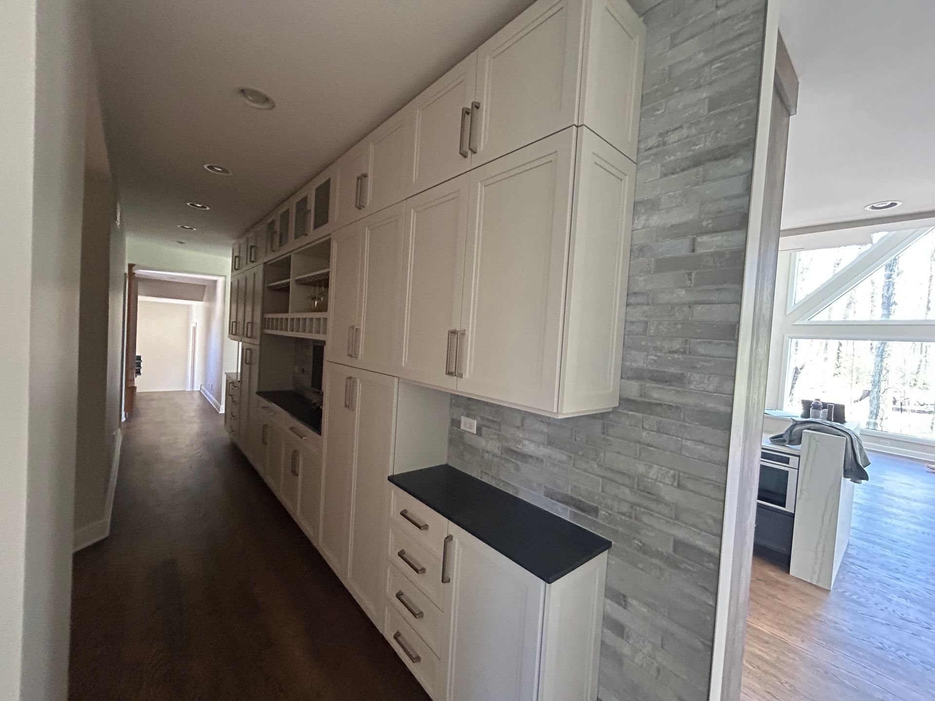 A kitchen with white cabinets and a black counter top