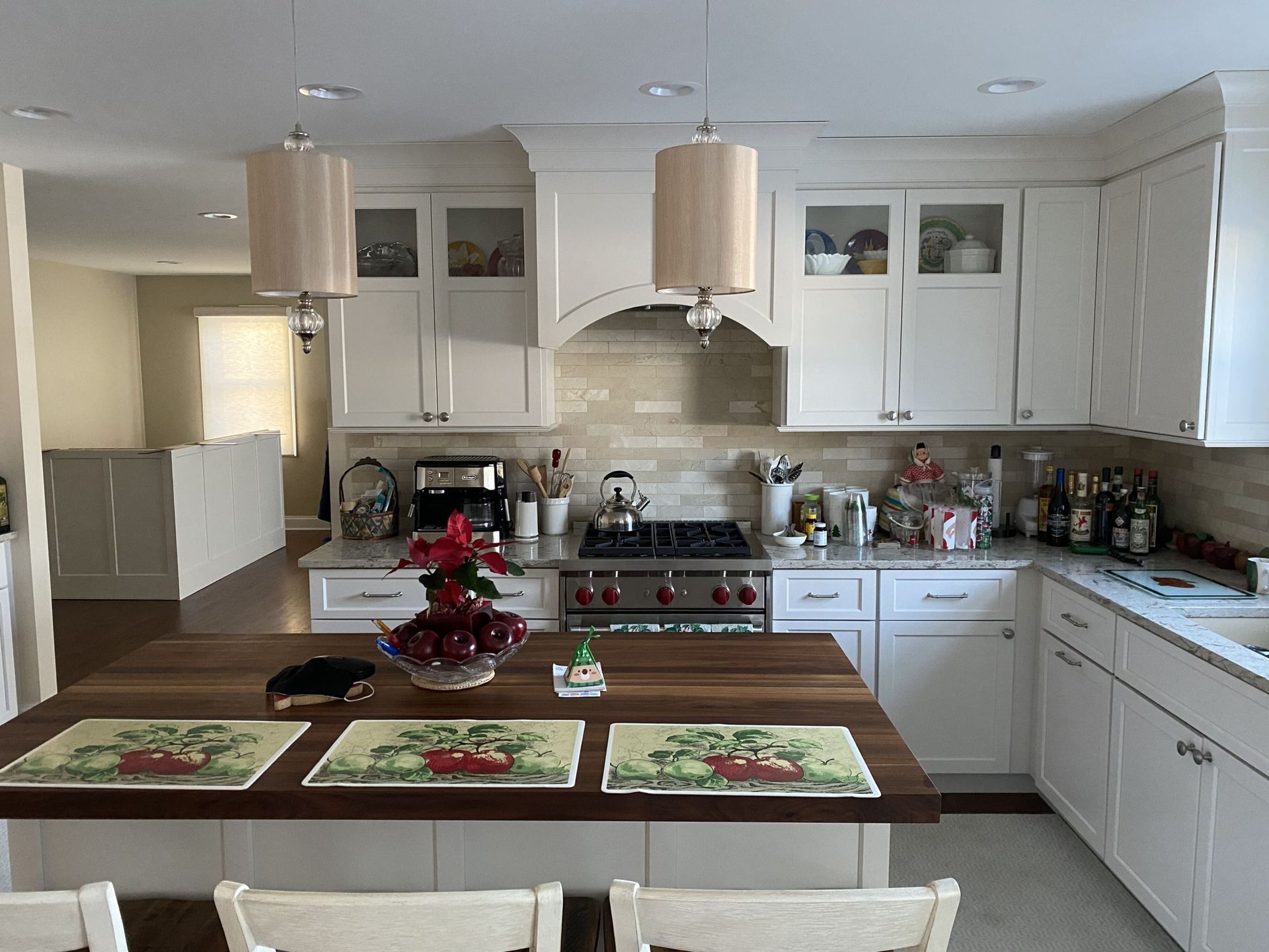 A kitchen with white cabinets and a wooden table