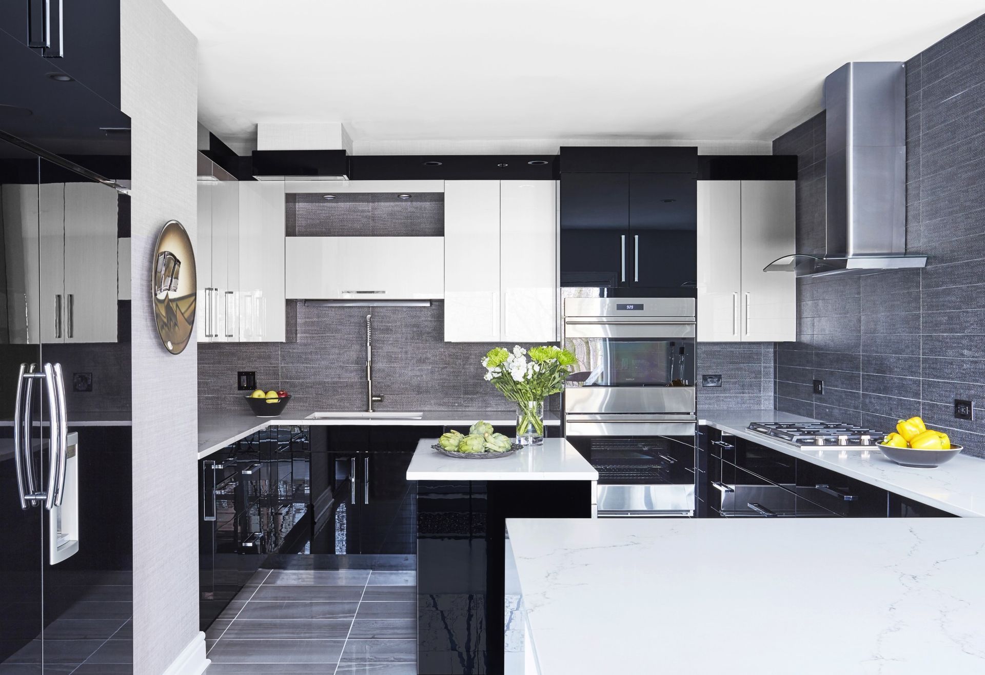 A kitchen with black and white cabinets and stainless steel appliances