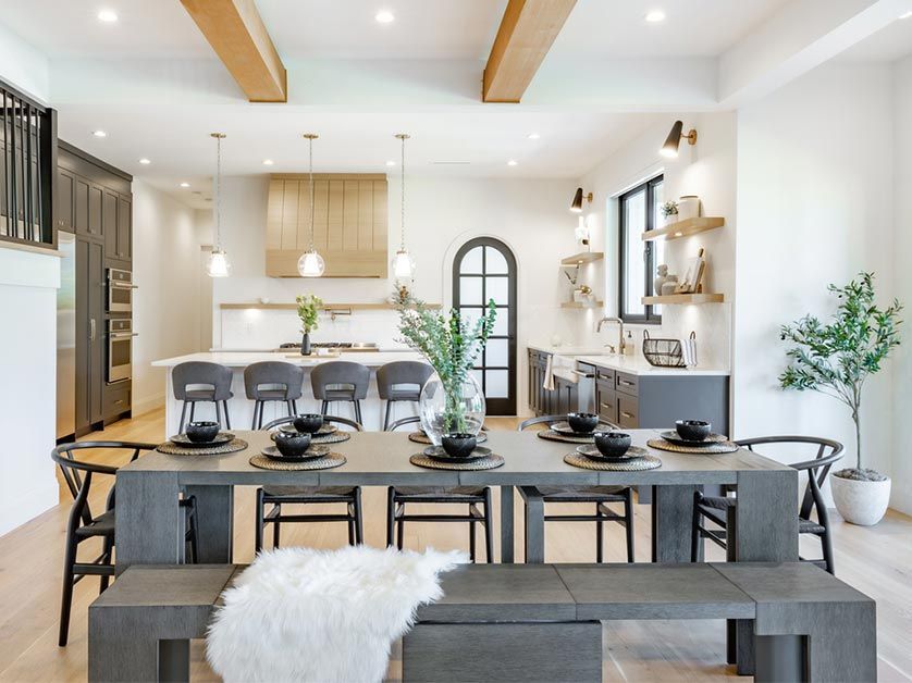 A dining room table with a bench and chairs in a kitchen.