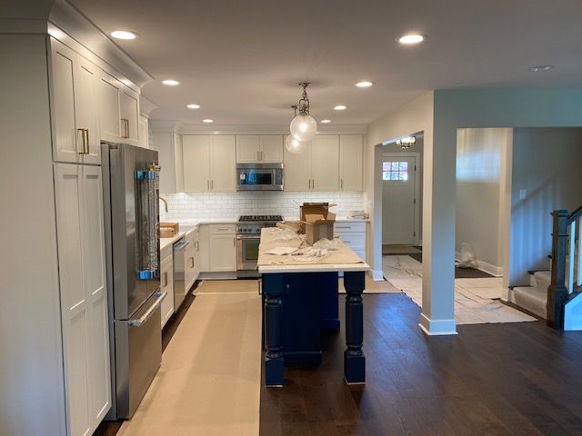 A kitchen with white cabinets and stainless steel appliances