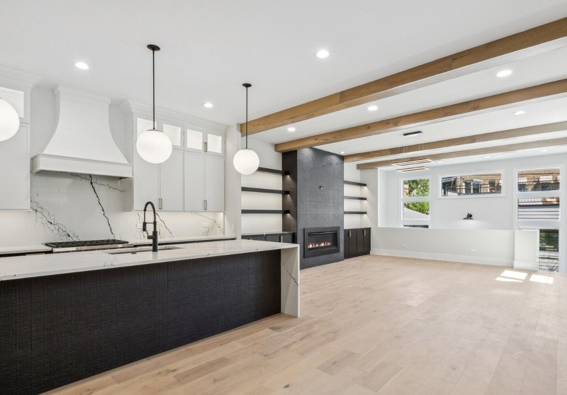 A kitchen with a large island and a fireplace in a house.