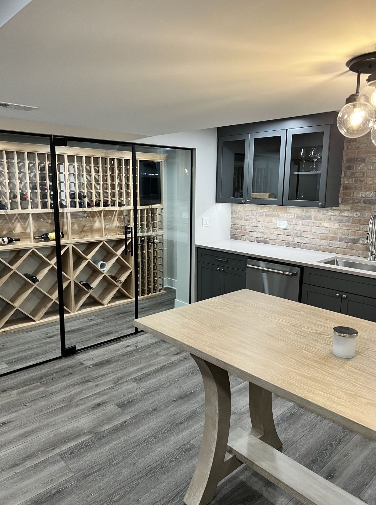 A kitchen with a table and a wine cellar.