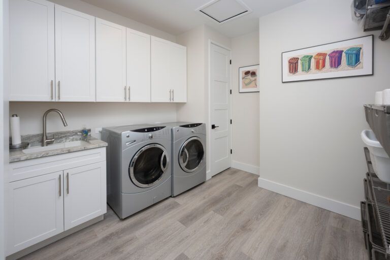 A laundry room with a washer and dryer and a sink.