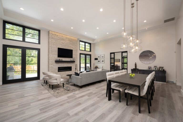 A living room and dining room in a house with a table and chairs.
