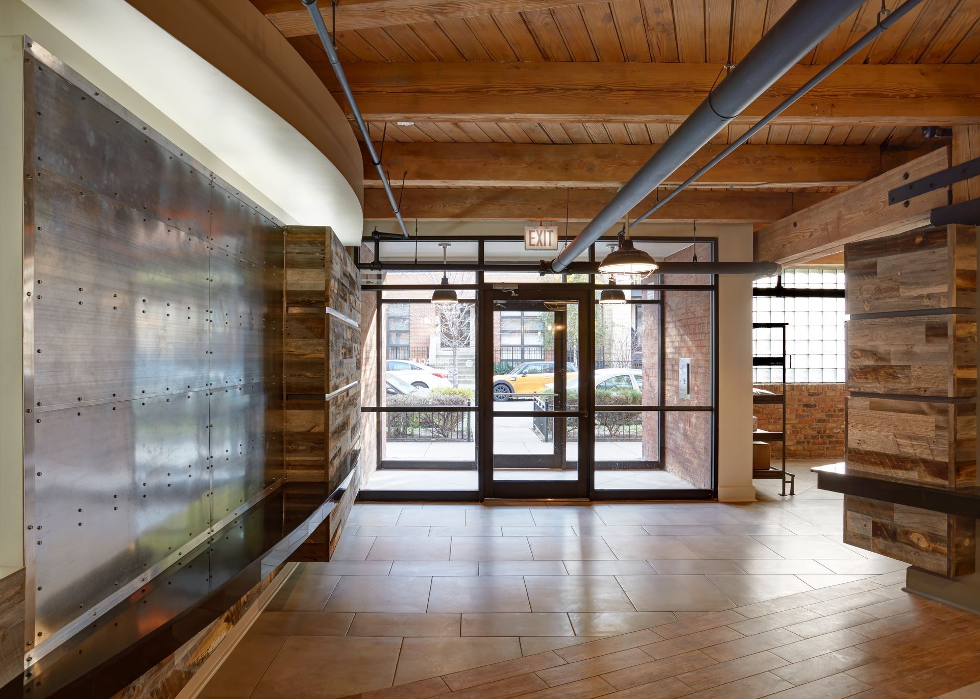 An empty room with a wooden floor and a metal wall