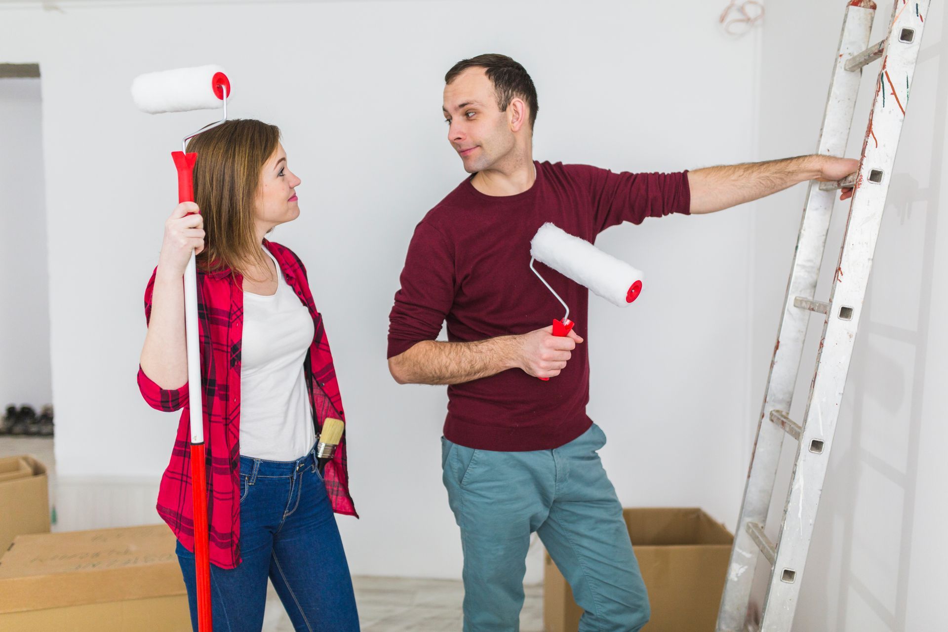 A man and a woman are painting a wall together.