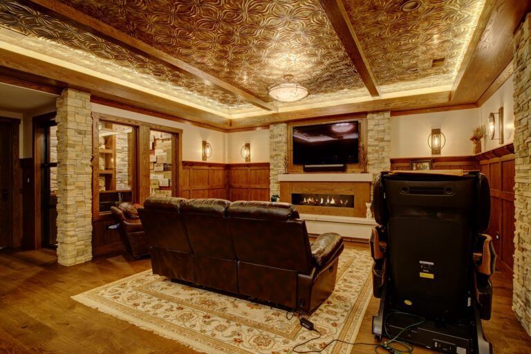 A living room with a couch , chairs , television and fireplace.