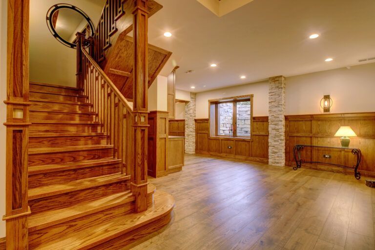 There is a wooden staircase in the middle of the room.