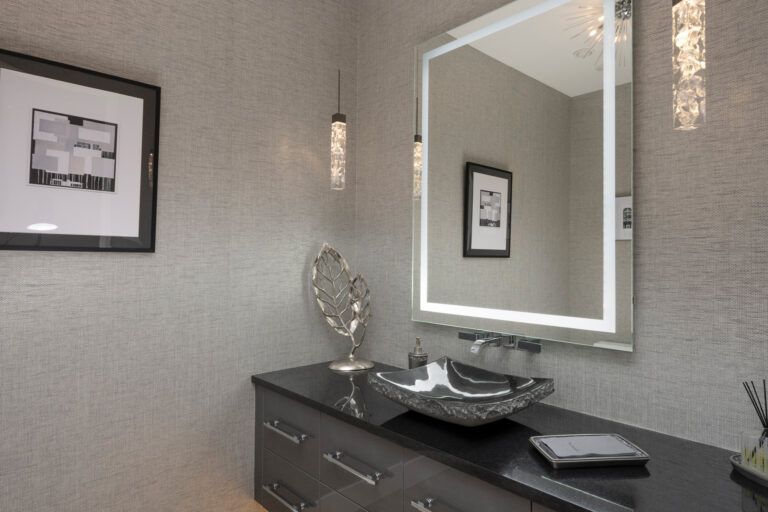 A bathroom with a large mirror and a sink