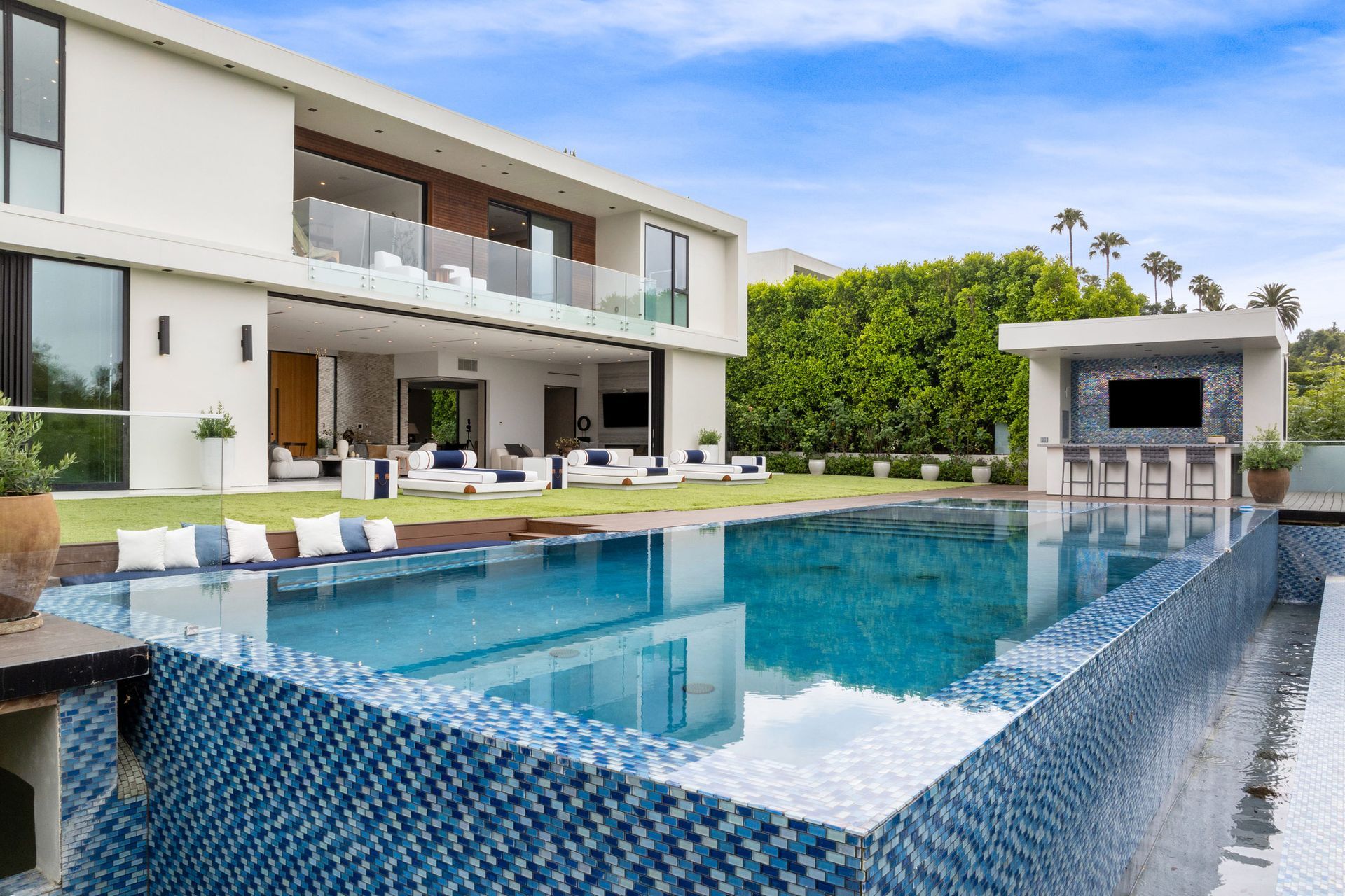 A large house with a swimming pool in front of it.