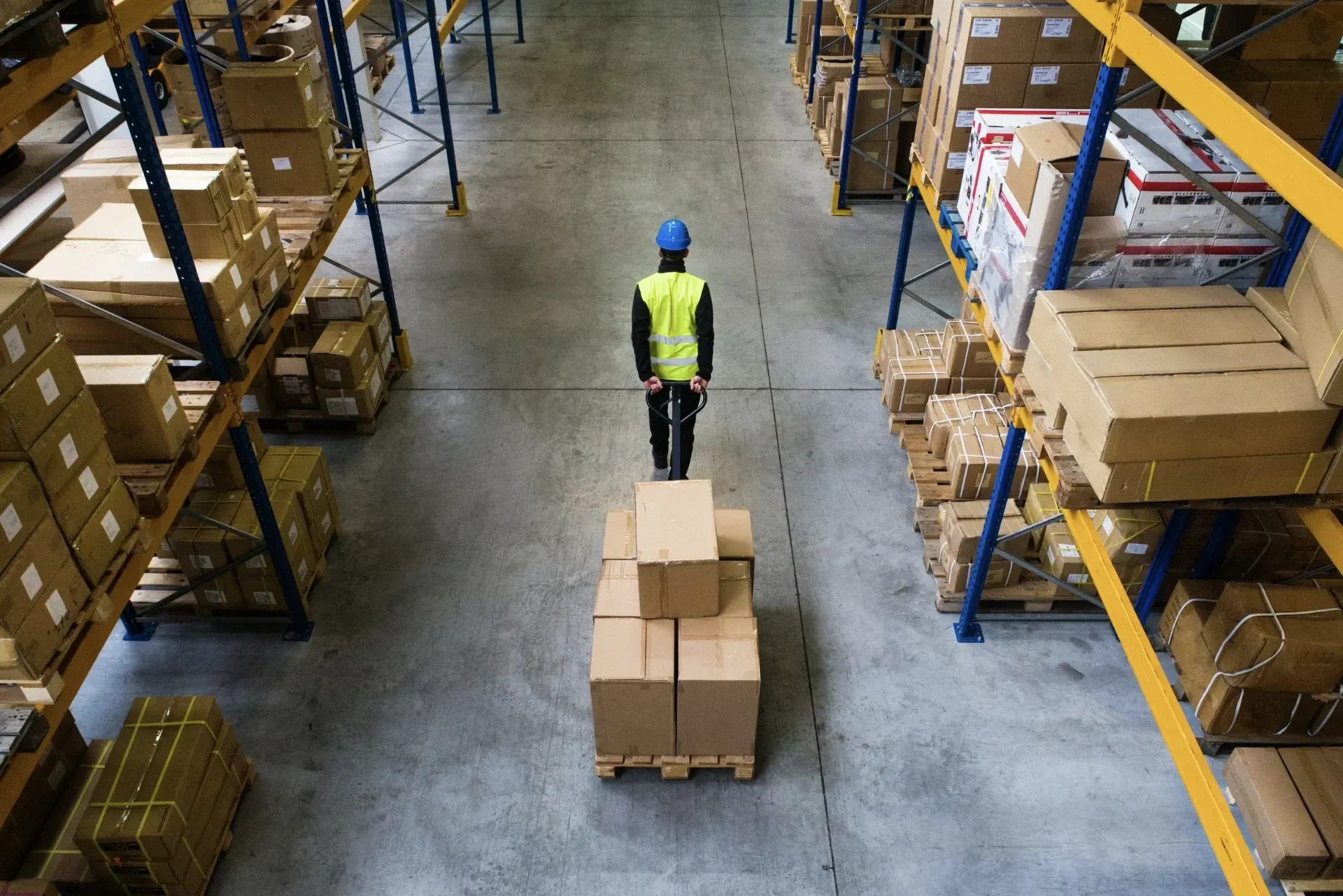 Empleado en centro de distribución moviendo cajas