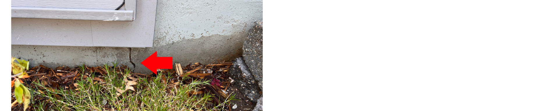 exterior foundation crack underneath a window, pointed at with a red arrow