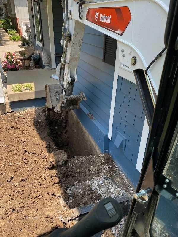 Excavator digging next to a home