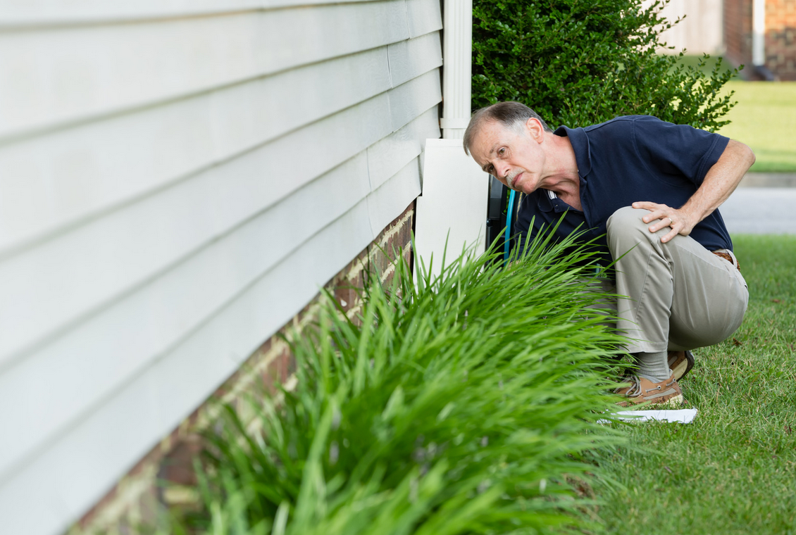 man inspecting home foundation