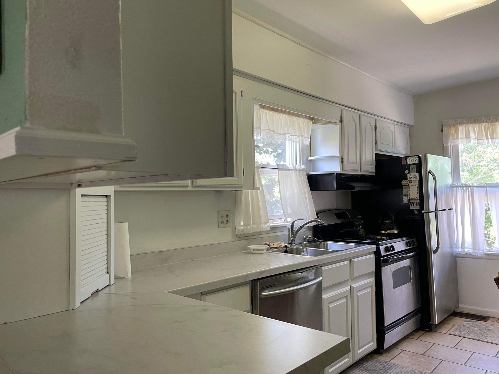 A kitchen with white cabinets and stainless steel appliances