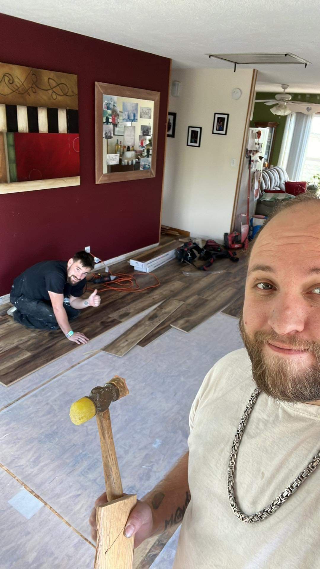A man is holding a hammer in a living room.