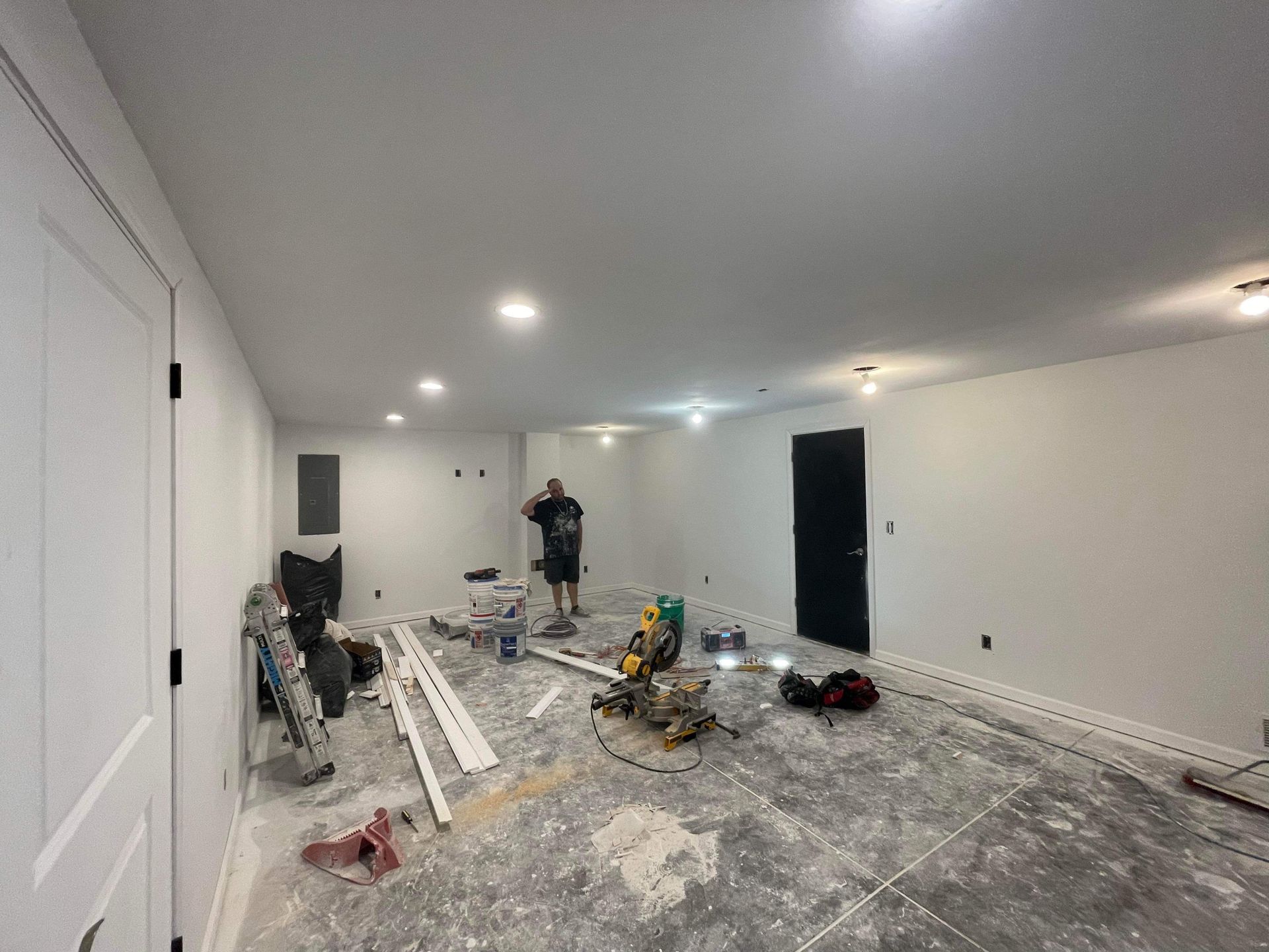 A man is standing in a room that is being remodeled.