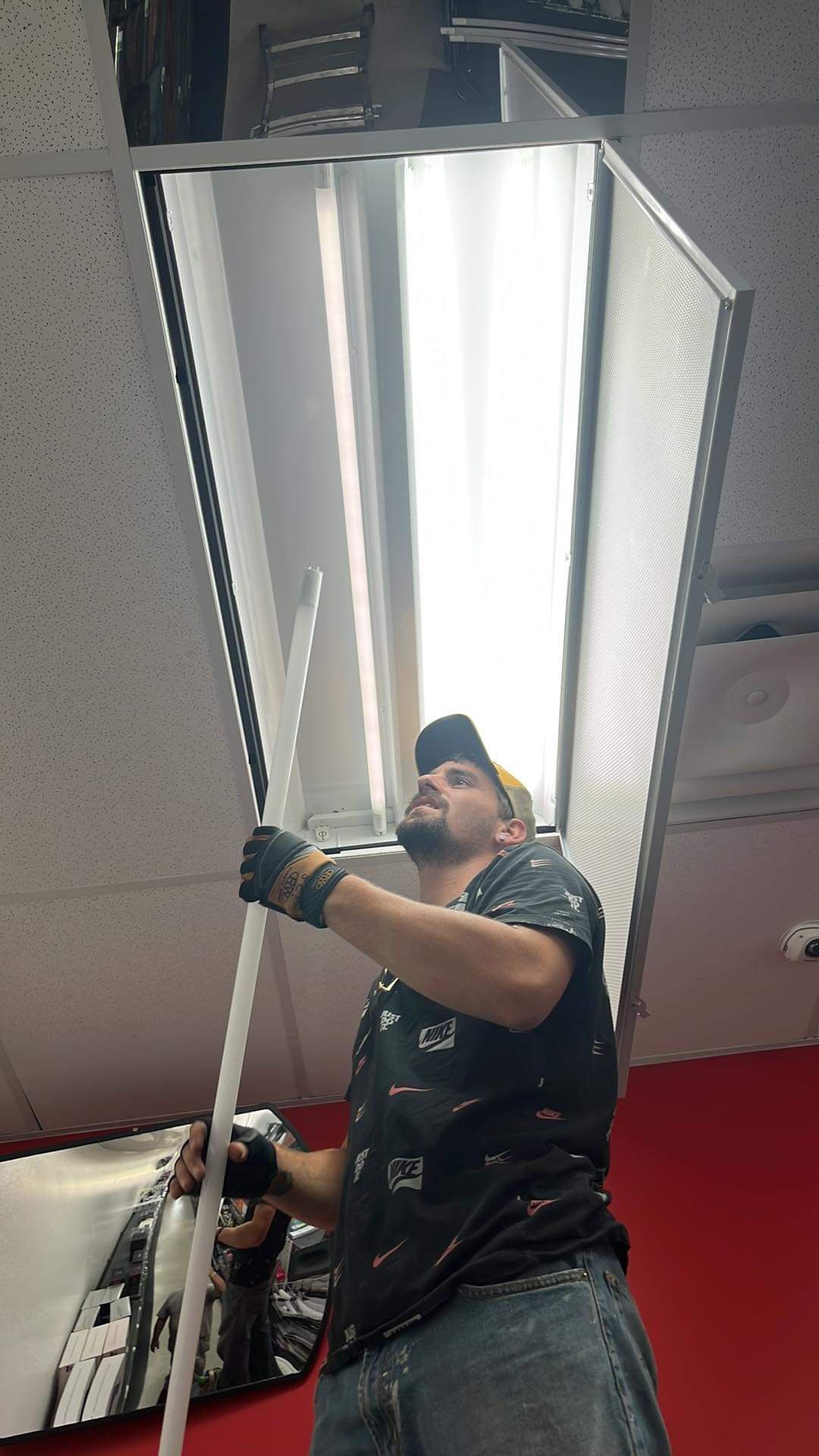 A man is working on a light fixture in a room.