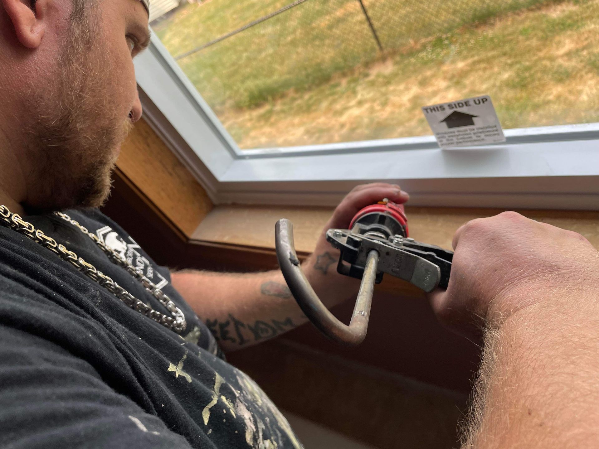 A man is fixing a window with a pair of pliers