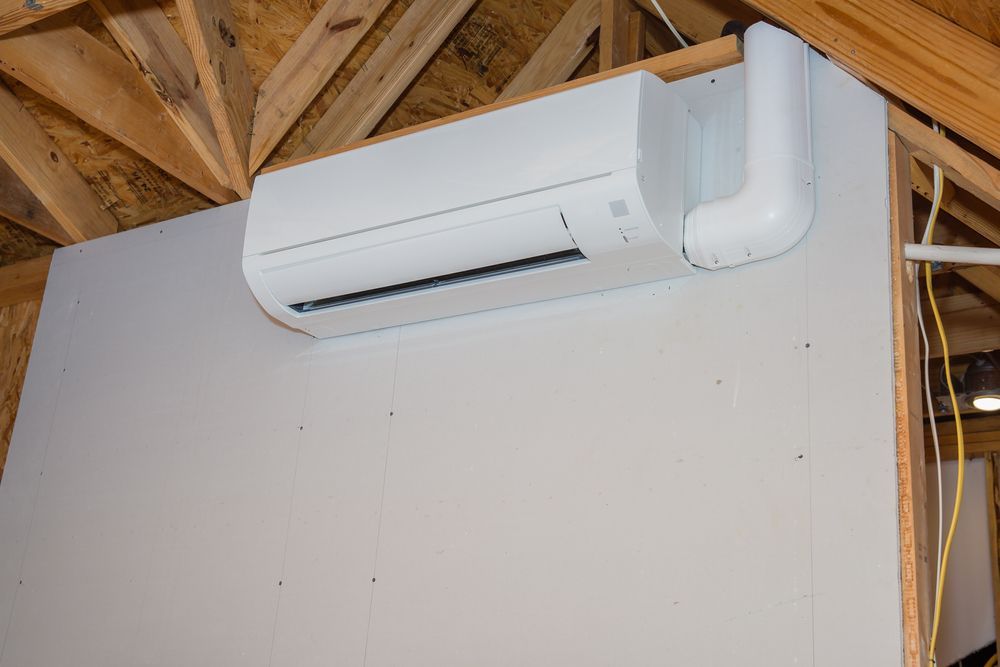 Wall-mounted white mini-split air conditioner near exposed wooden ceiling beams