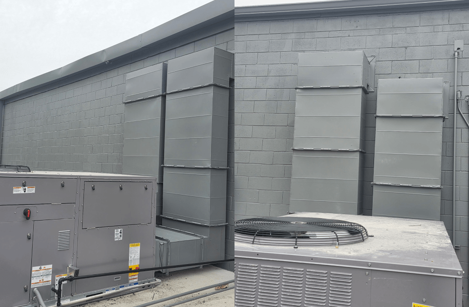 Rooftop HVAC units and large gray ventilation ducts on a flat industrial building