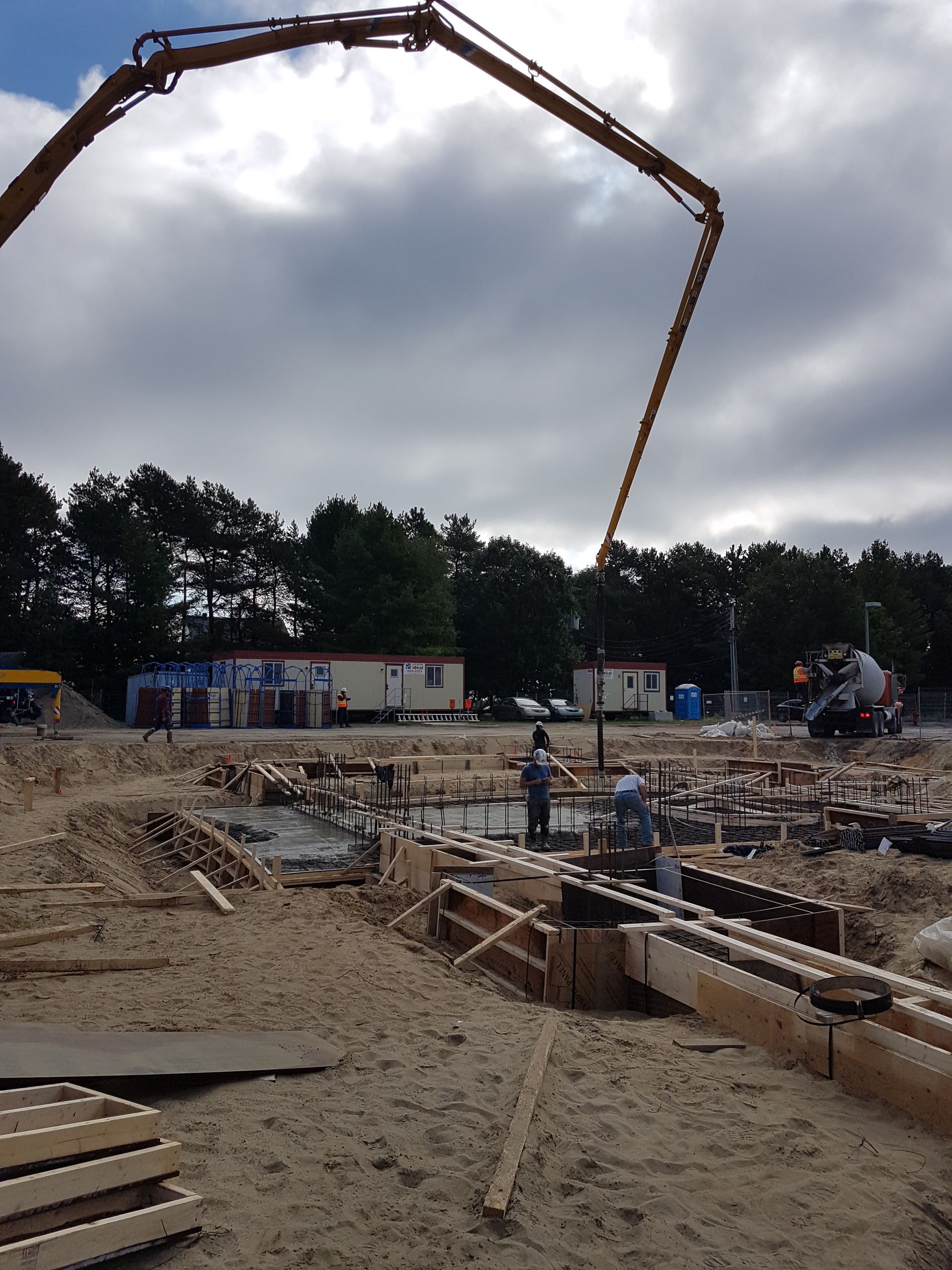 Un chantier avec une pompe à béton au premier plan