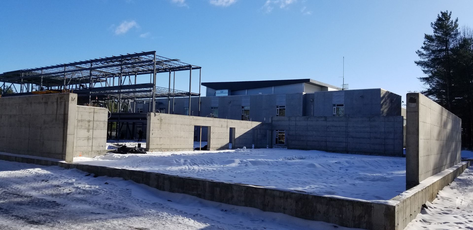 Un grand bâtiment est en construction sous la neige.