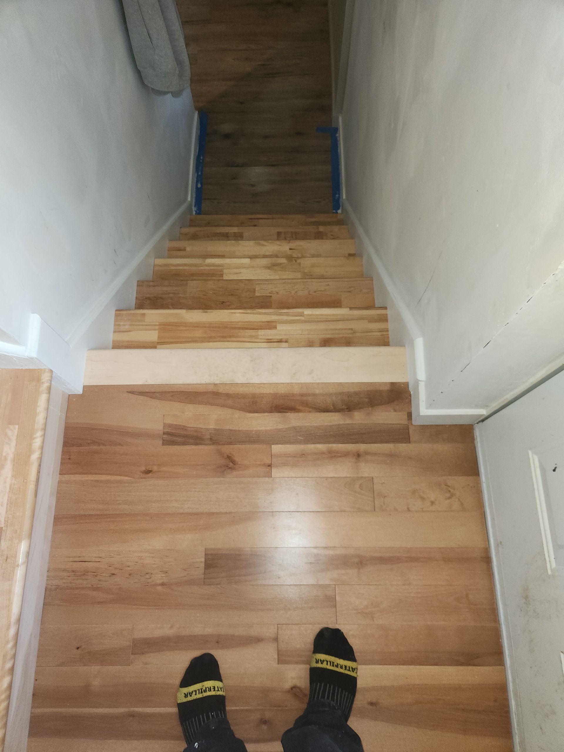 Une personne se tient debout sur un escalier en bois.