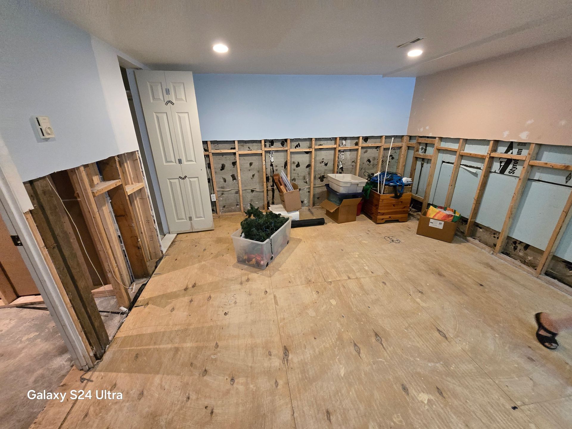 Une pièce en cours de rénovation avec parquet et murs en bois.