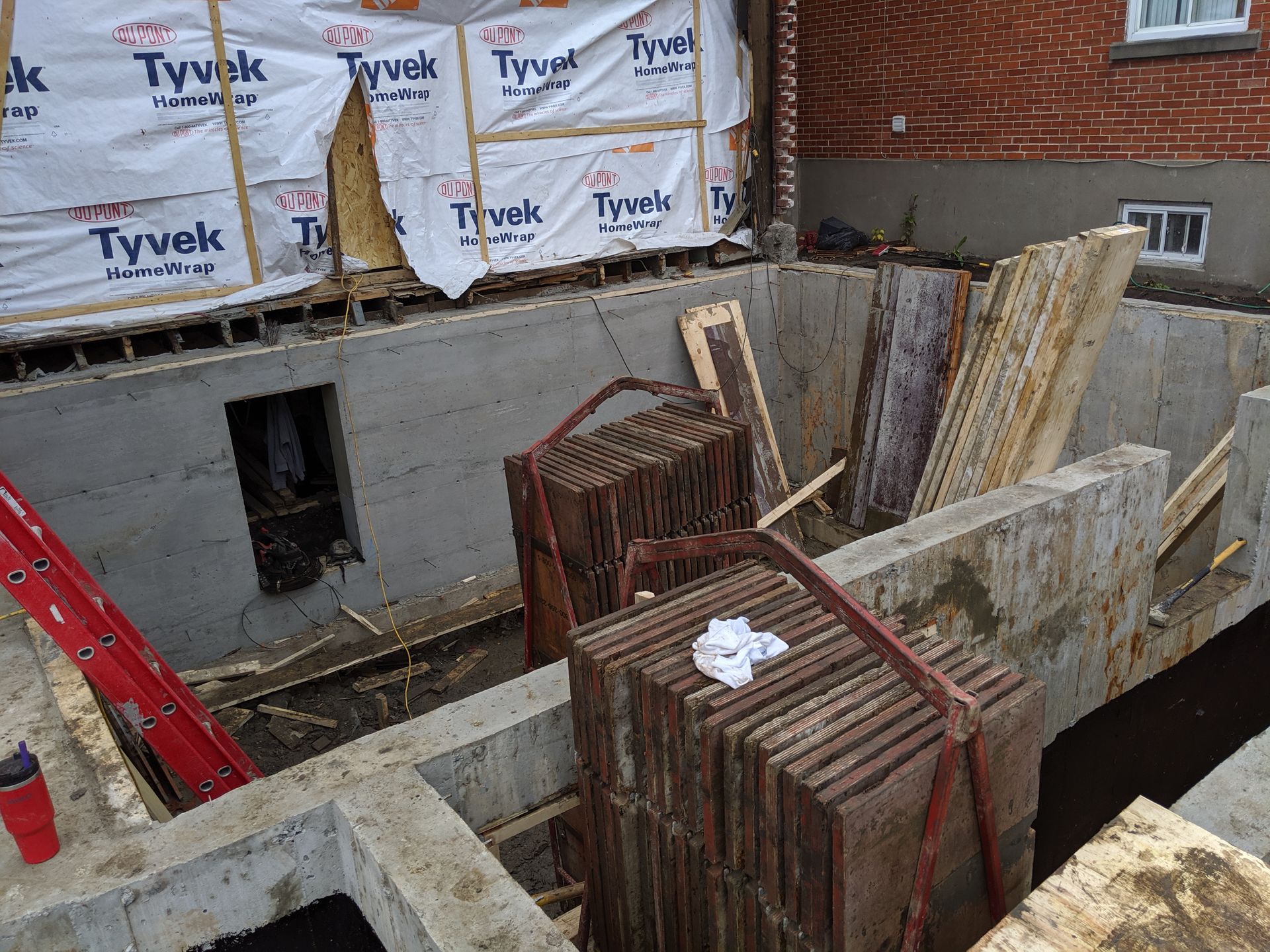 Une pile de briques est soulevée par une grue.