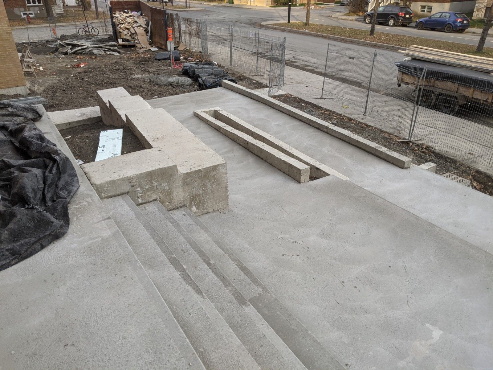 Un escalier en béton est en cours de construction sur le bord d'une route.