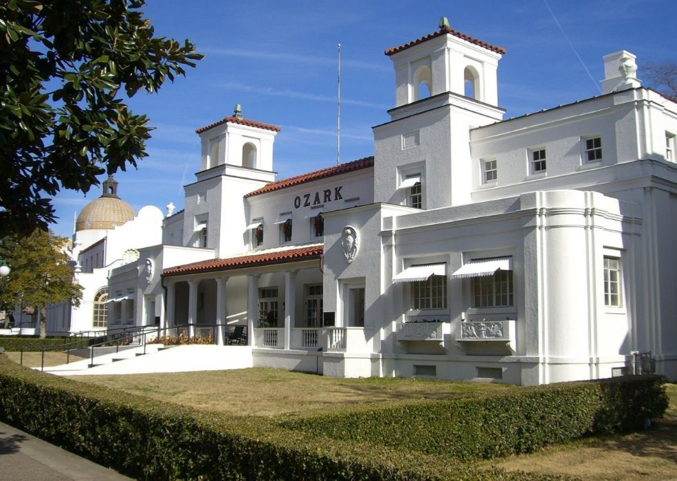White Ozark Bathhouse in Hot Springs, Arkansas with red tile roof and manicured lawn.