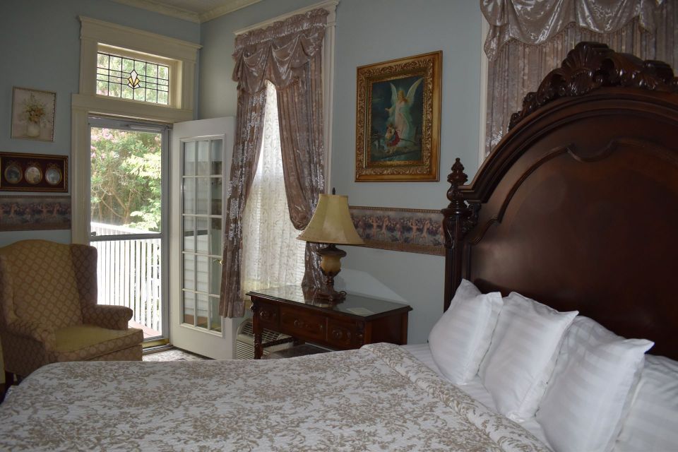 Bedroom with large bed, ornate headboard, and French doors leading to a porch.