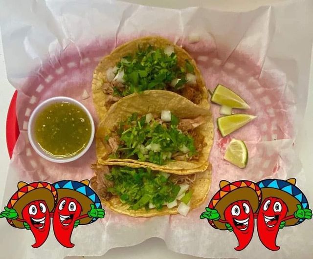 A basket of tacos with a bowl of salsa and limes.