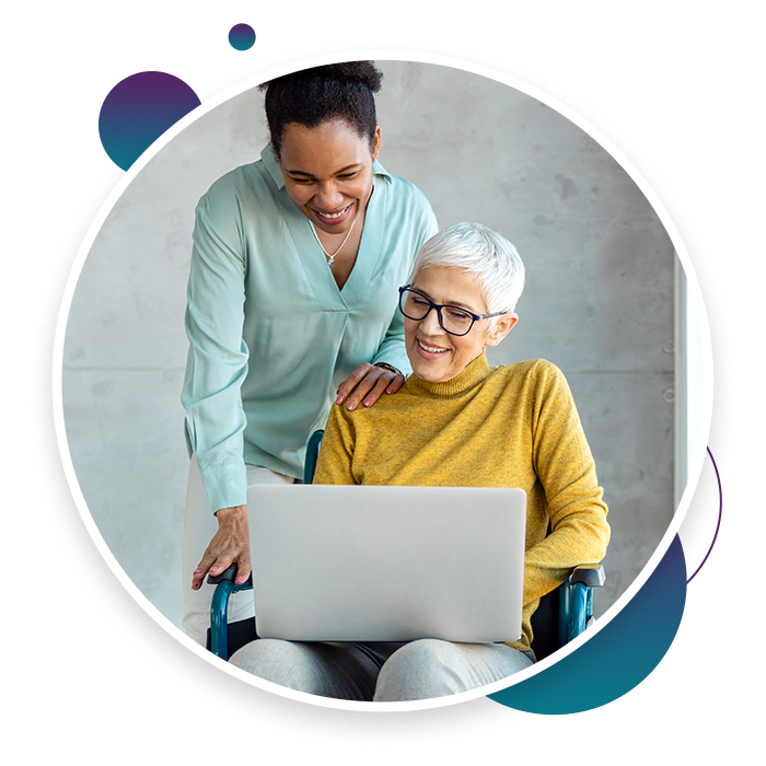 an adult and an elderly woman staring at a laptop