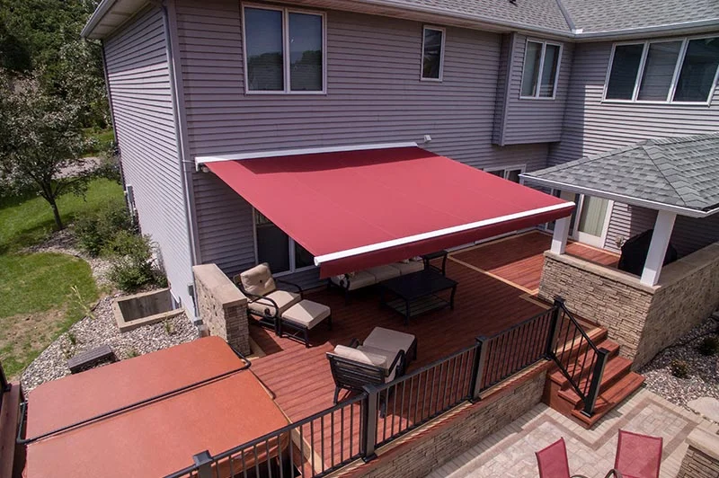 Sunesta awning covering deck chairs and outdoor sofa on a patio. 