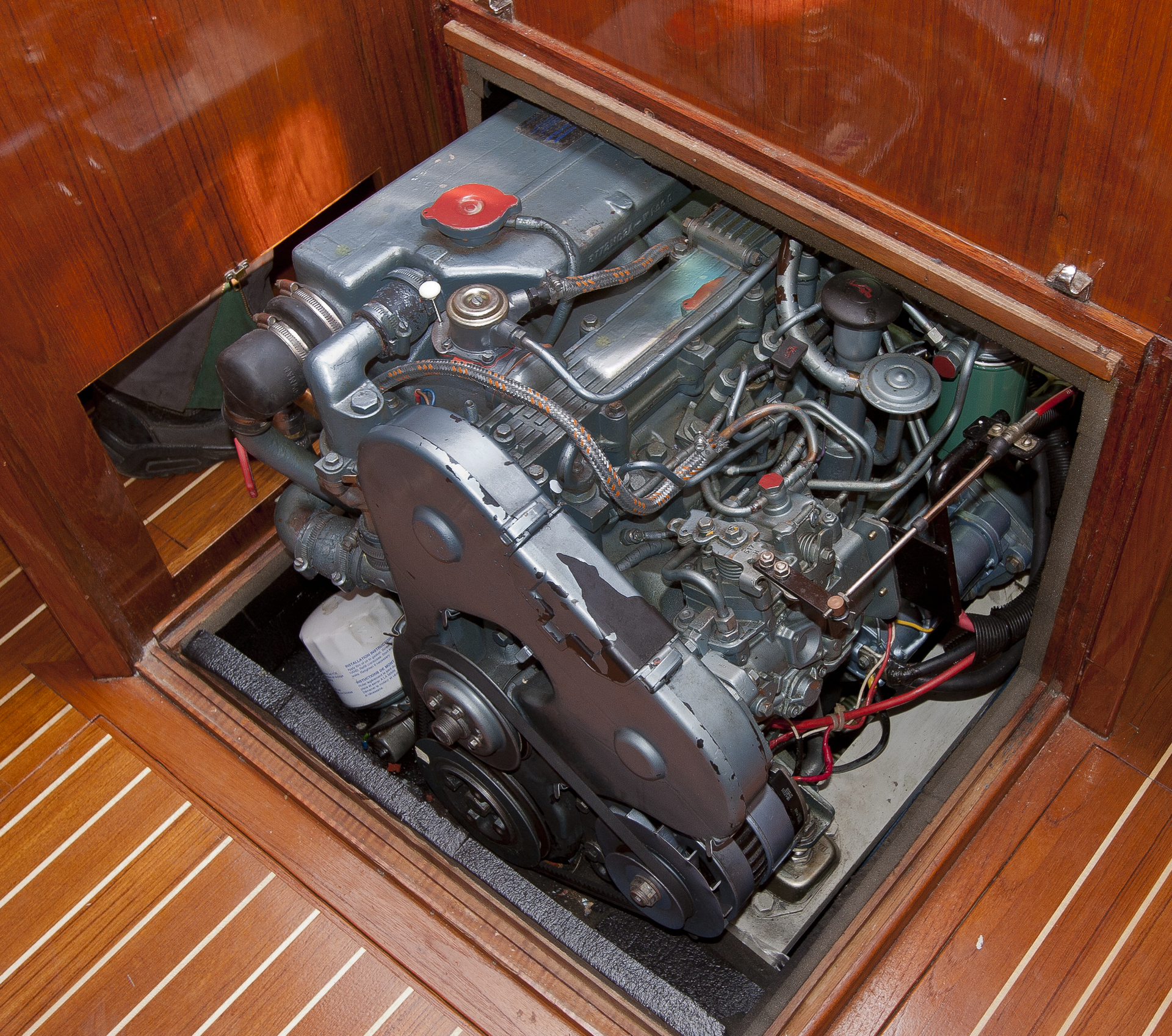 A boat engine is sitting inside of a wooden cabinet