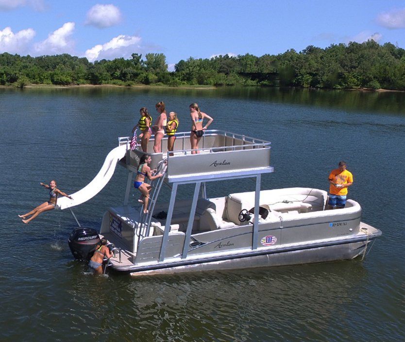 a group of people are on a boat with a slide attached to it