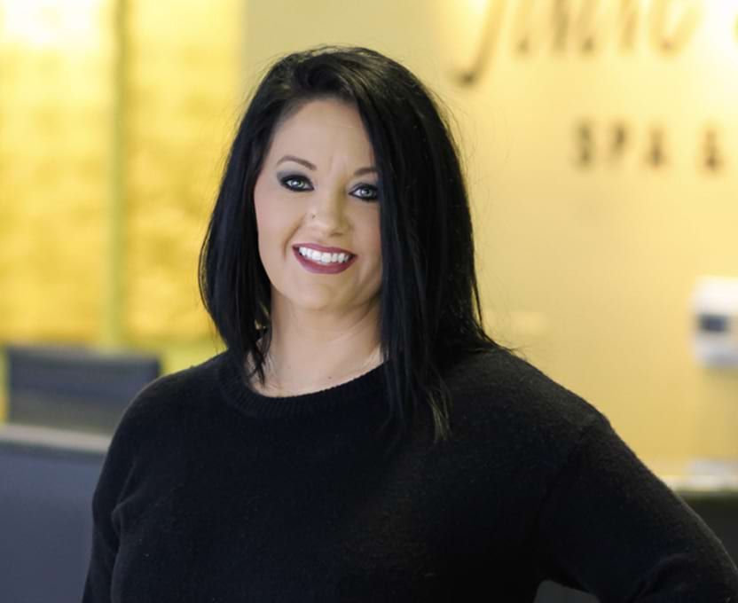A woman in a black sweater is smiling for the camera.